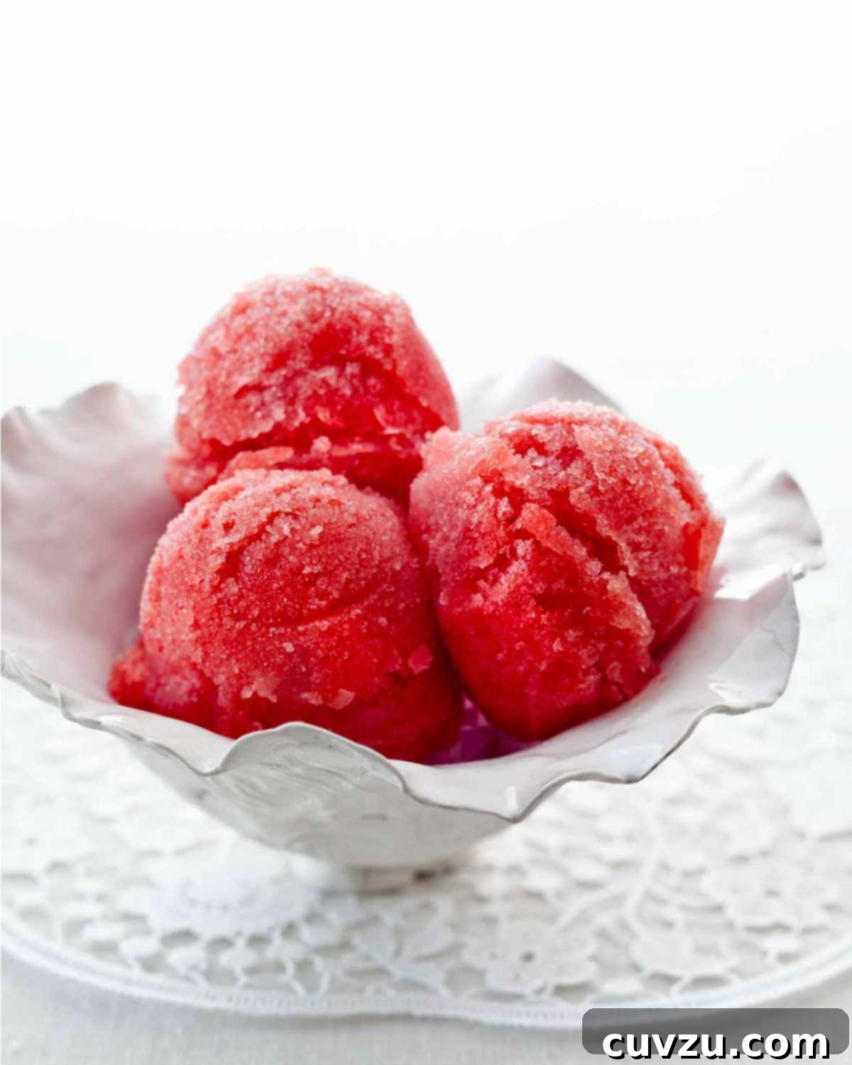 Picking the Perfect Watermelon 8 Three scoops of vibrant pink watermelon sorbet presented in an elegant white serving dish, ready to be enjoyed.