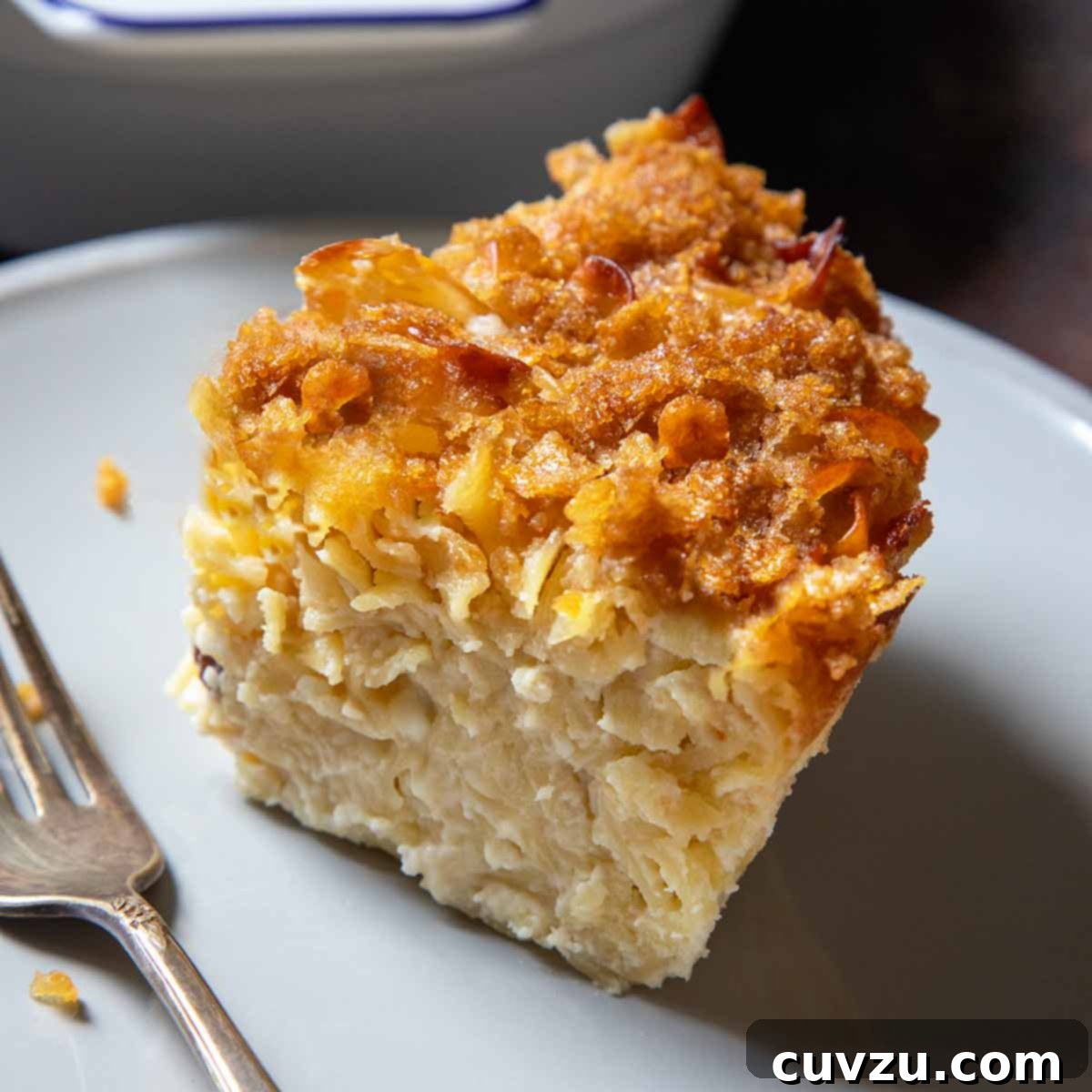 Light Up Your Table: 11 Hanukkah Recipes 4 A casserole dish of sweet noodle kugel; in front is a plate with a slice of kugel on it.