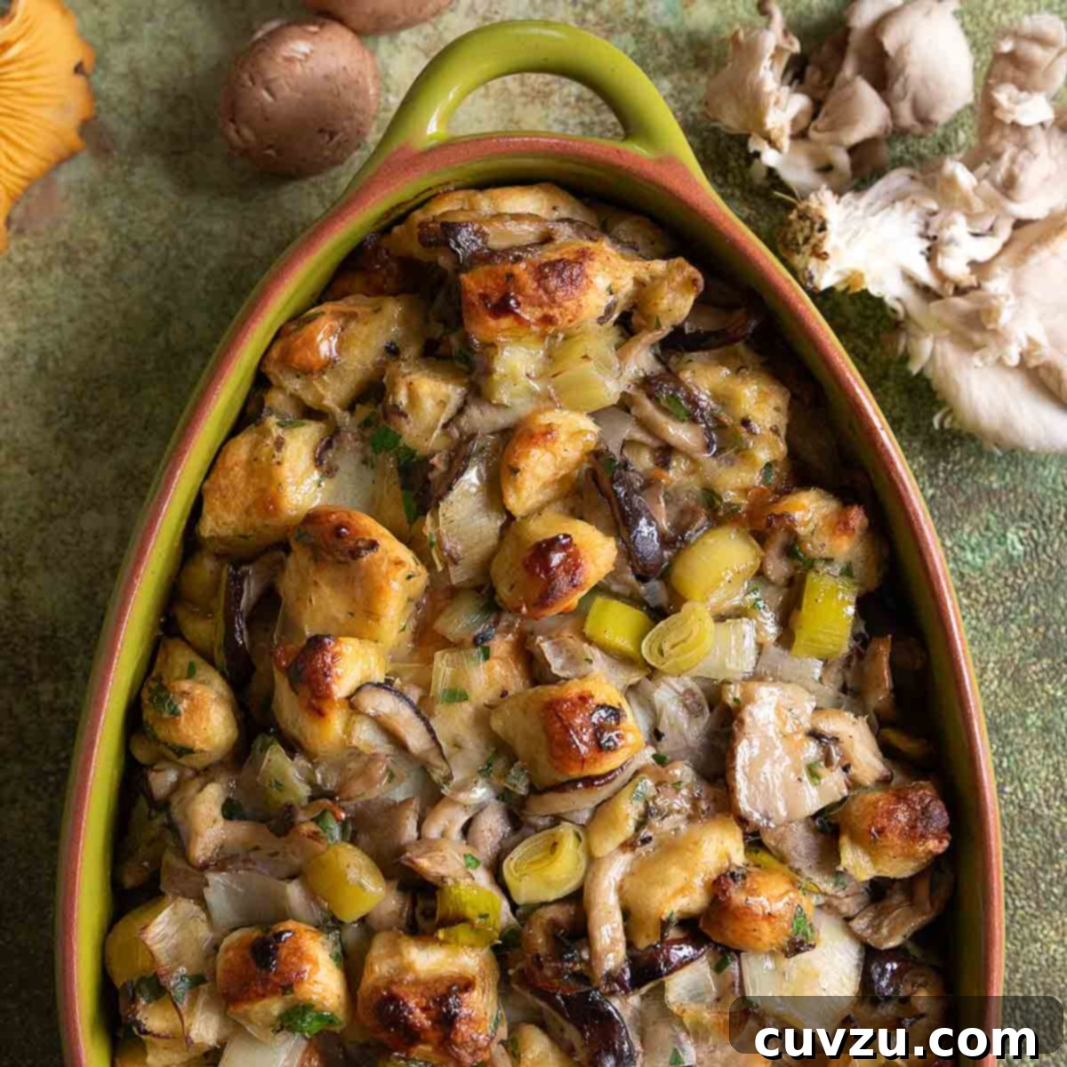 An oval casserole dish filled with wild mushroom stuffing.