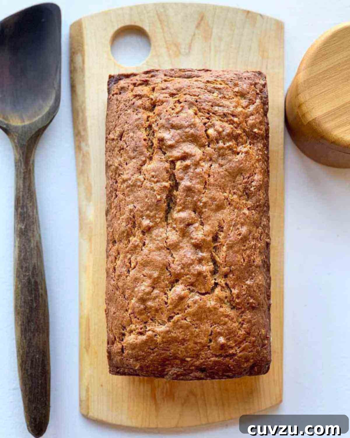 Warm Spiced Pear Bread 3 An overhead view of a freshly baked loaf of pear bread on a cutting board, highlighting its golden crust and rustic charm, ready for slicing.