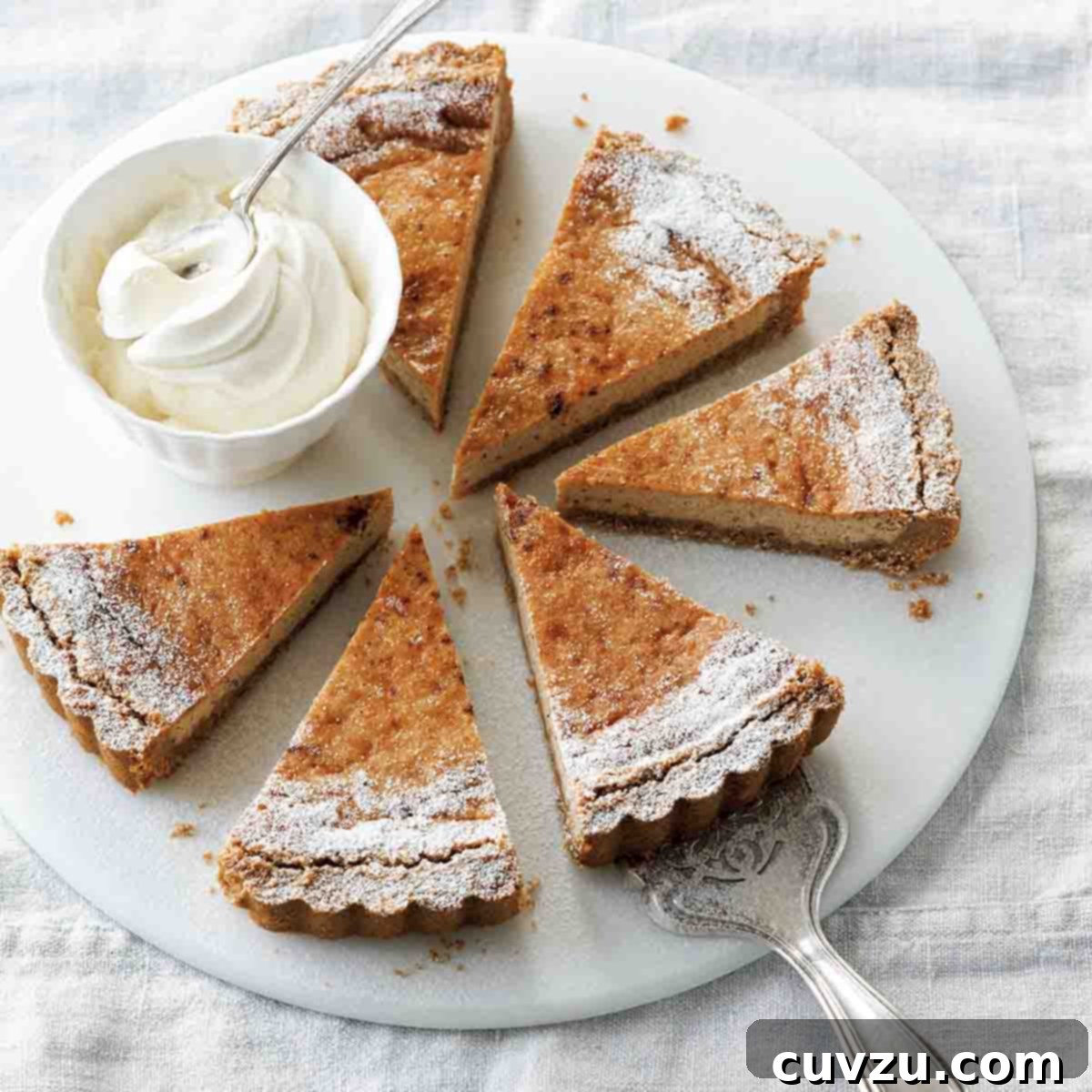 A round white plate with six slices of eggnog pie and a dish of whipped cream.