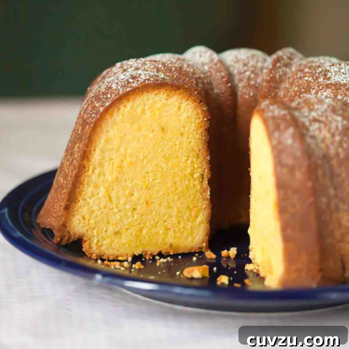 A partially cut Portuguese orange olive oil cake.