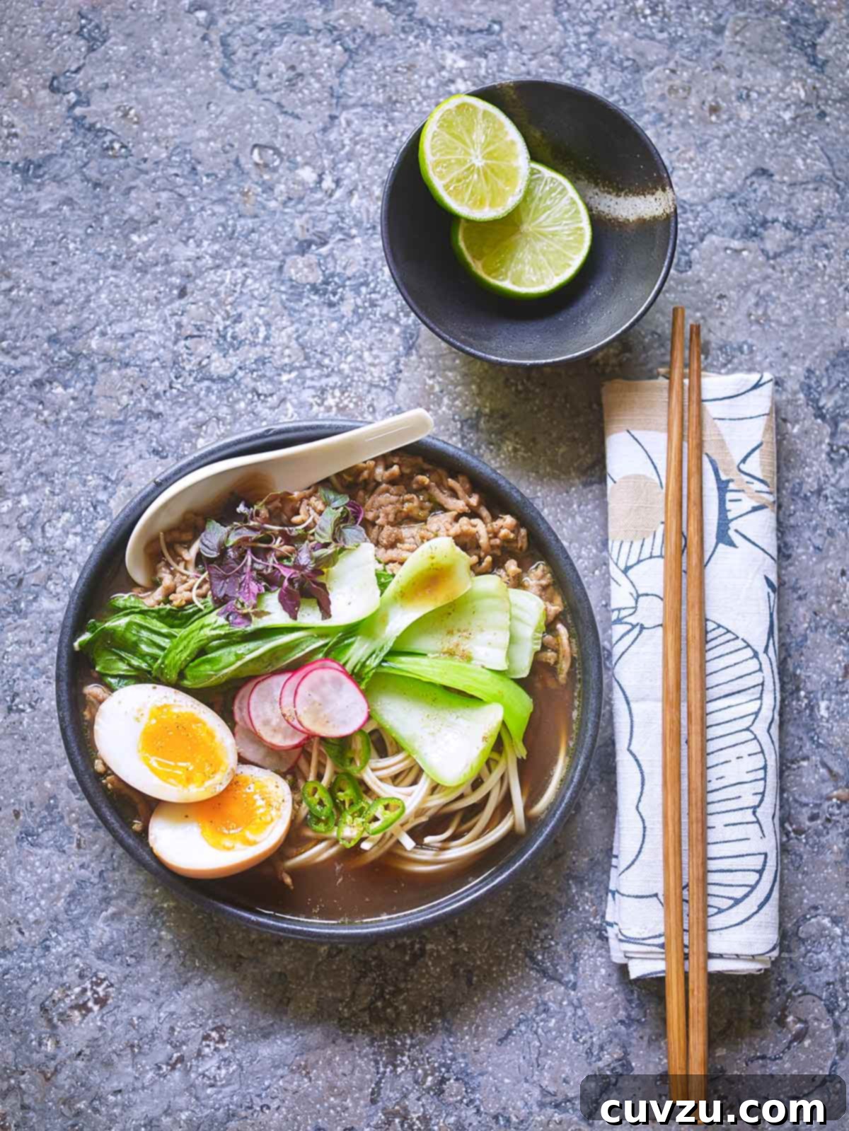 Feast for Fortune: New Year's Eats to Savor and Avoid 3 A black bowl filled with curried pork ramen, jammy egg, bok choy, sliced radish, and basil.