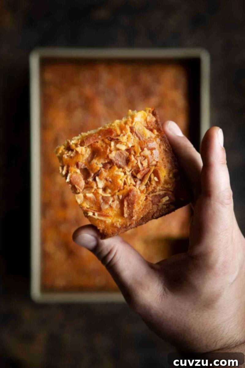 Feast for Fortune: New Year's Eats to Savor and Avoid 4 A man's hand holding a square of bacon cornbread