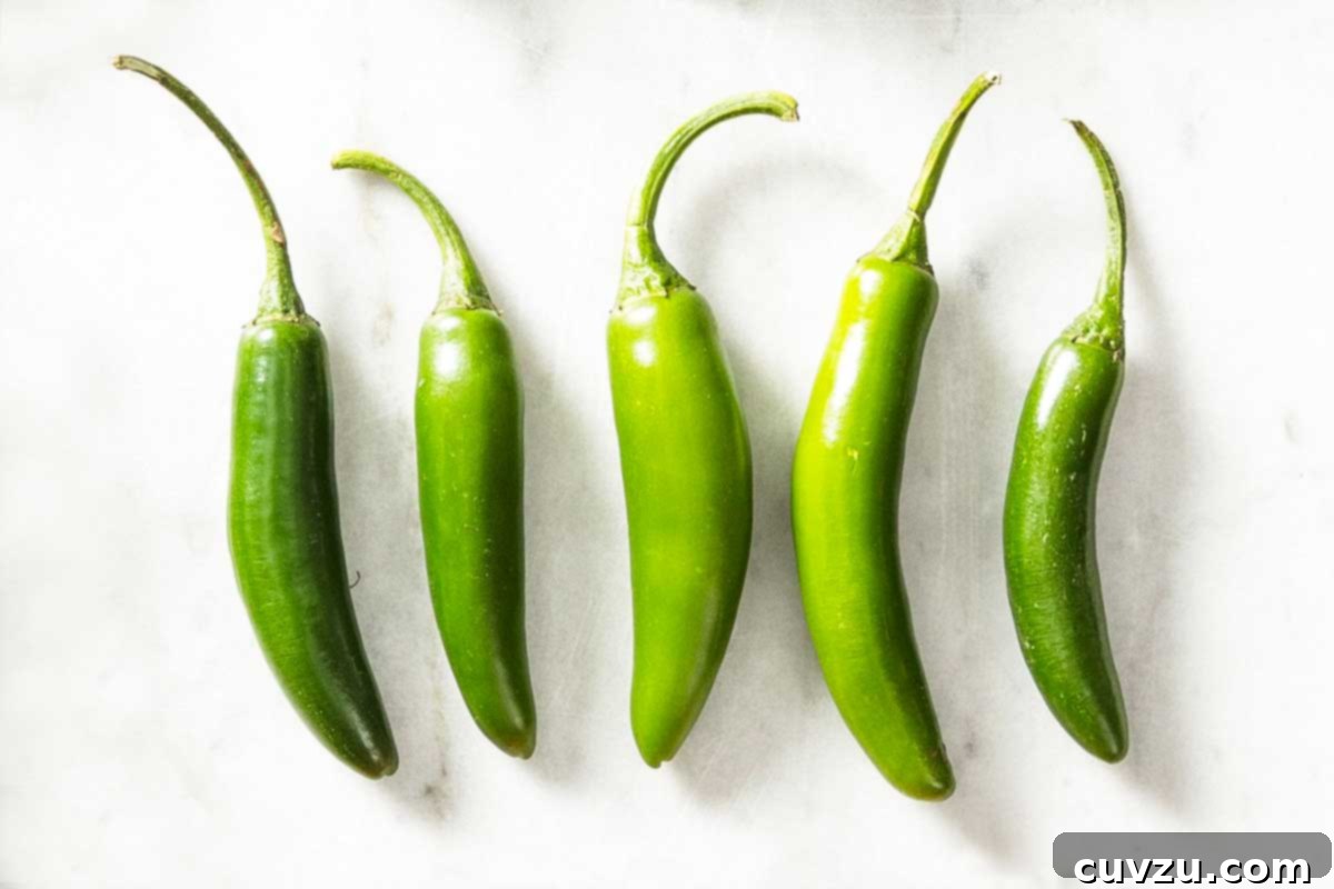 Fresh Chile Peppers: Decoding the Differences 7 Five slender, vibrant green Serrano peppers, known for their punchy medium-hot heat and bright citrusy flavor, often used raw.