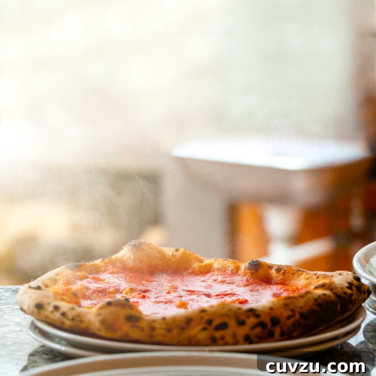 A whole pizza marinara on a stack of white plates.