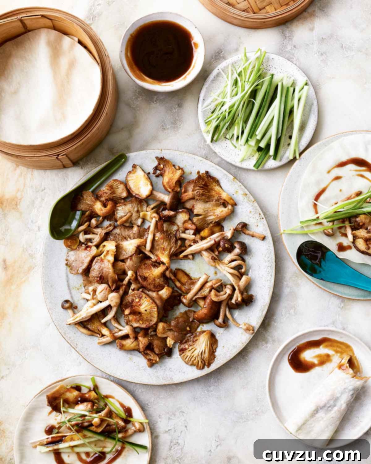 Peking-Style Mushroom Pancakes 2 A vibrant spread of Peking mushroom pancake components, including roasted mushrooms, hoisin sauce, sliced cucumber, and julienned scallions, artfully arranged in individual dishes on a rustic wooden table.