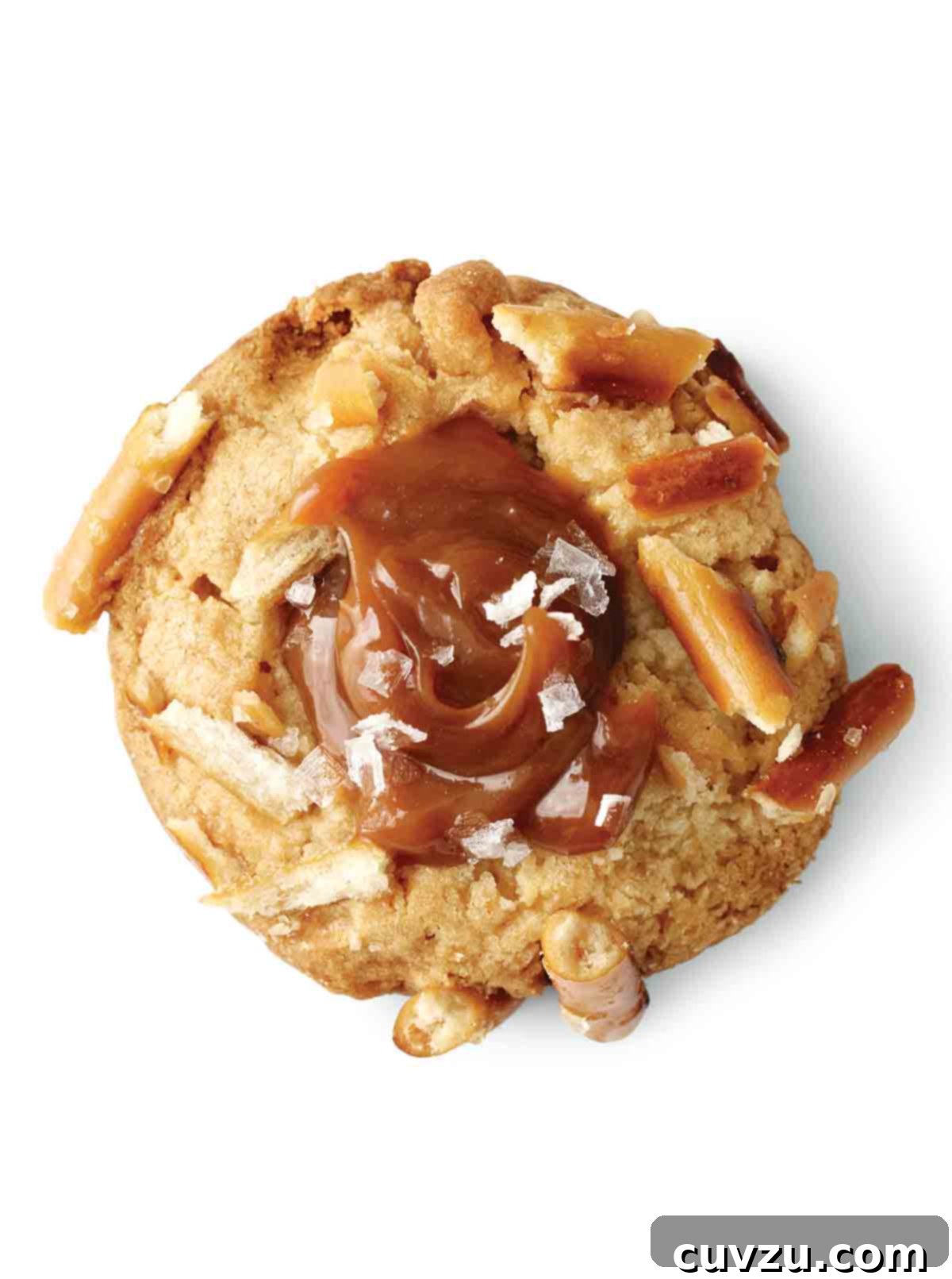 A perfectly baked salted caramel and pretzel cookie, featuring visible pretzel pieces and glistening flakes of sea salt on top, resting on a white surface.
