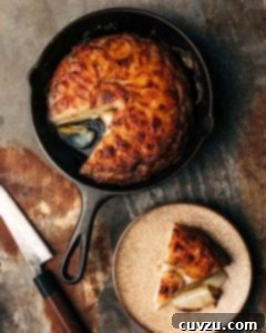 A potato galette in a cast-iron skillet with one wedge missing.