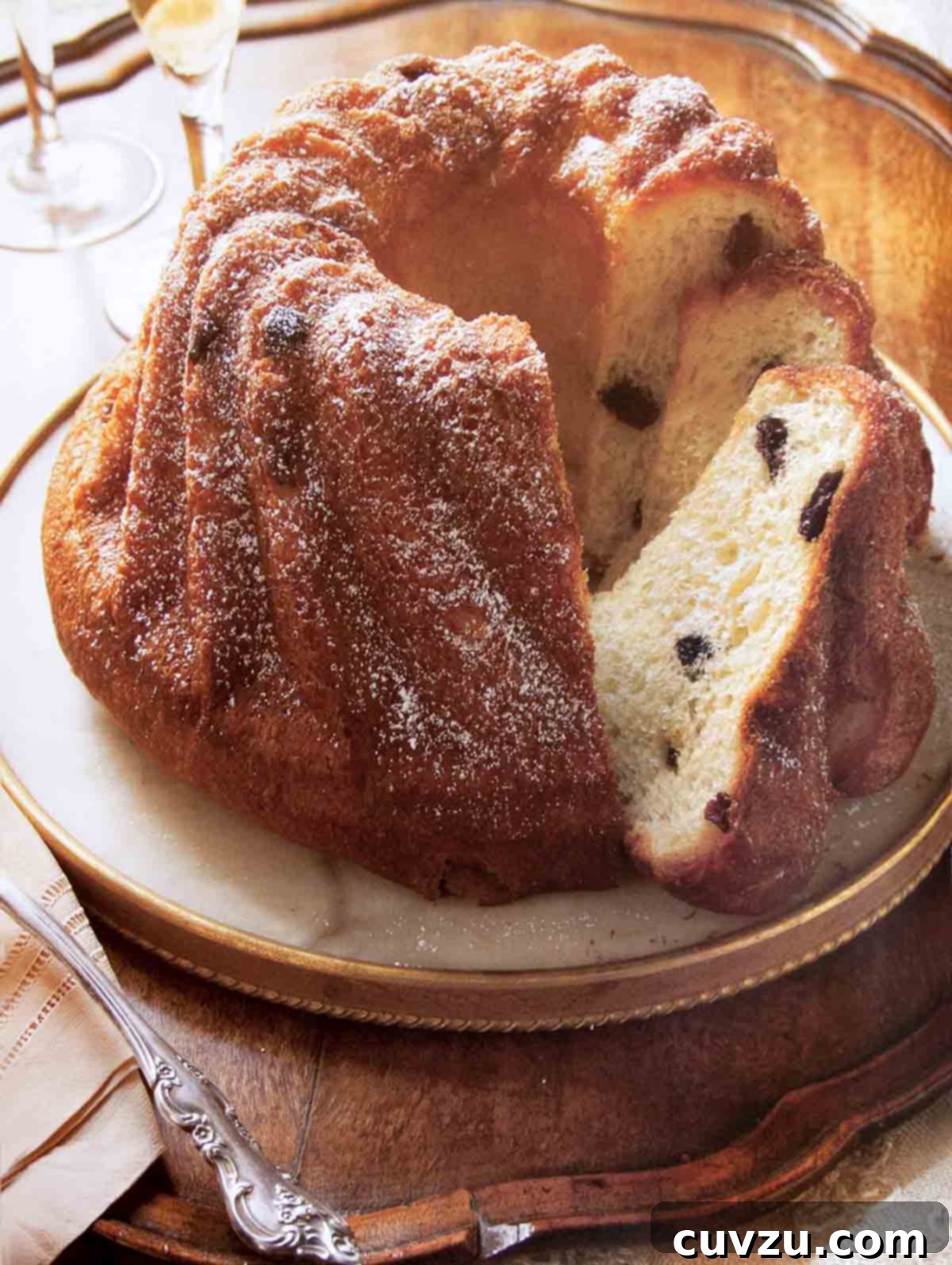 Alsatian Bundt Cake 2 A beautifully sliced Kugelhopf in a round metal platter, showcasing its golden crust and airy interior.