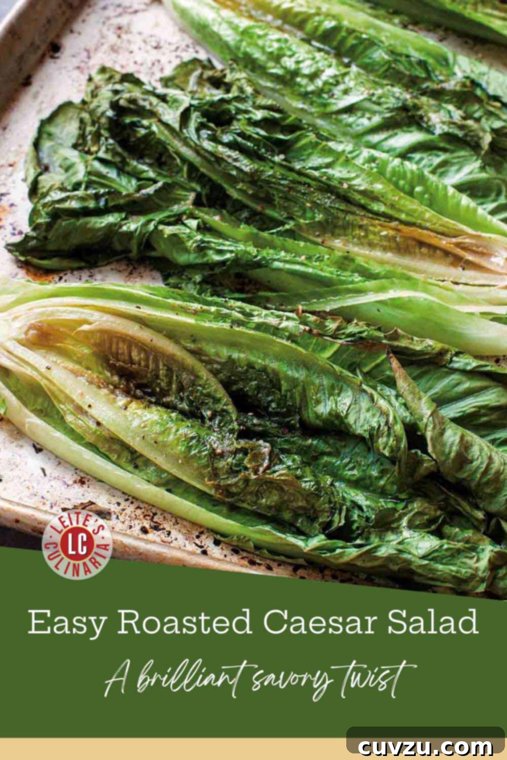 Roasted romaine halves glistening with dressing on a rustic metal baking sheet, their edges wilted and slightly browned from the oven.
