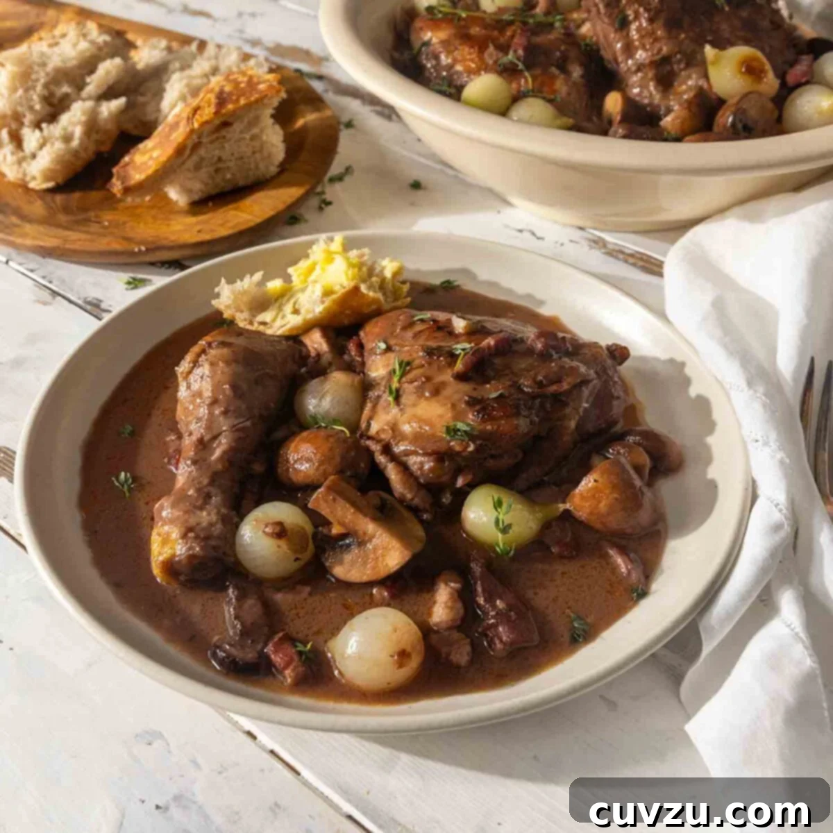 Julia Child Cooks Up a Series for HBO Max 6 Two bowls of coq au vin on a table with sliced bread and fresh herbs.