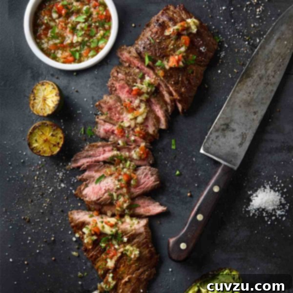 Flame-Kissed Skirt Steak with Vibrant Salsa 10 Sliced skirt steak topped with salsa with a bowl of salsa and charred lime halves on the side.