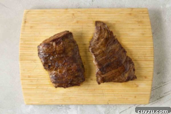 Flame-Kissed Skirt Steak with Vibrant Salsa 14 Two seared pieces of skirt steak on a cutting board.