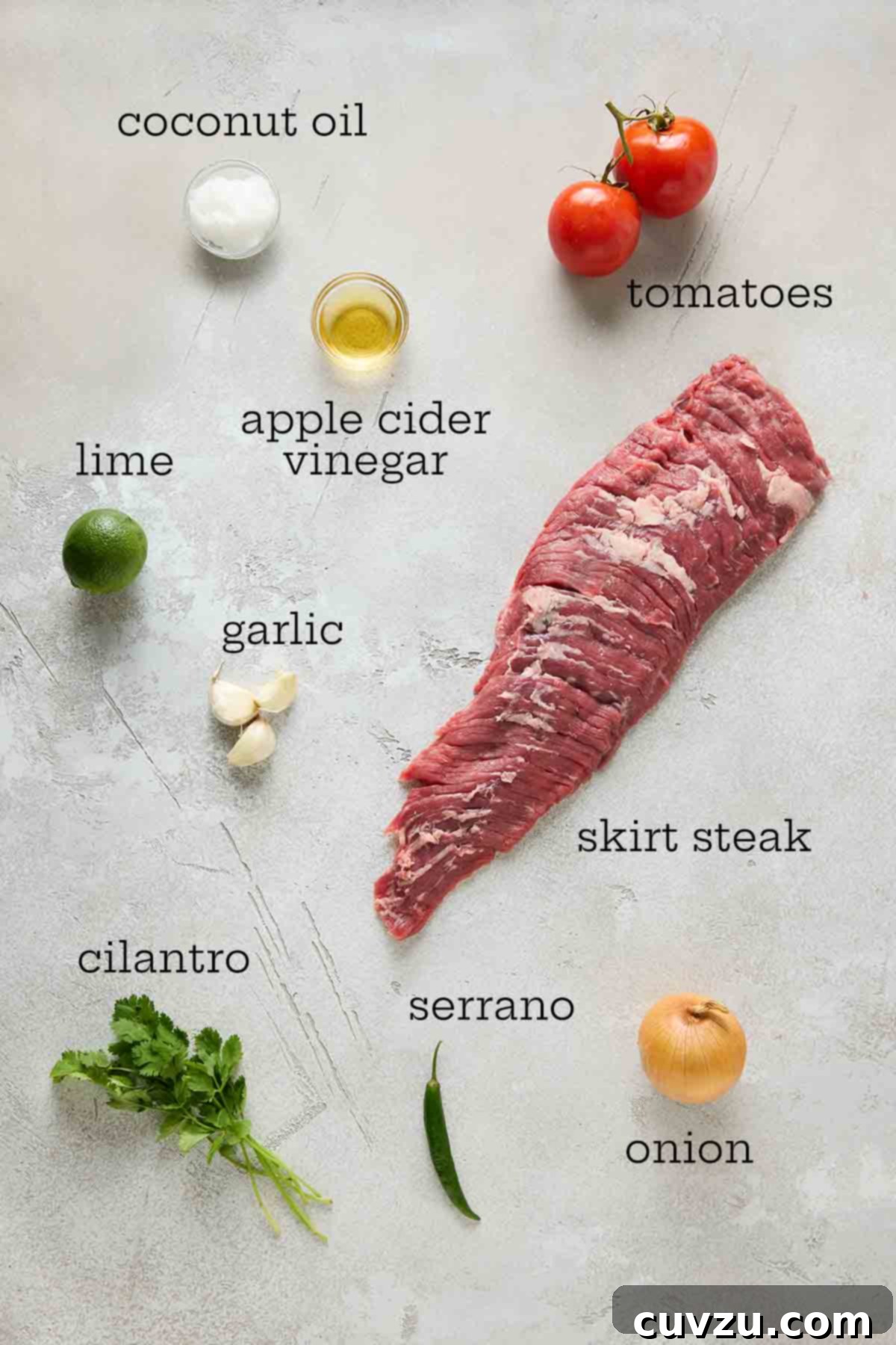 Flame-Kissed Skirt Steak with Vibrant Salsa 5 Fresh ingredients laid out for seared skirt steak with salsa: coconut oil, bright red tomatoes, apple cider vinegar, limes, garlic, raw skirt steak, fresh cilantro, serrano pepper, and a red onion.