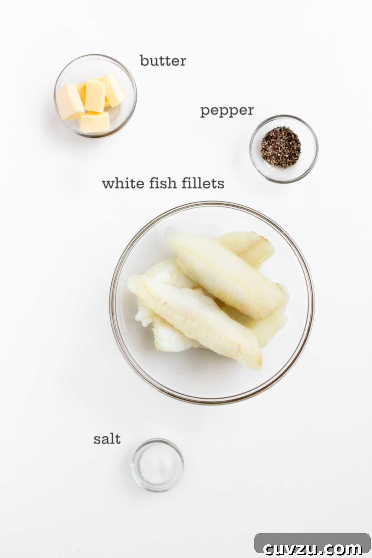 Lemon Butter Baked Fish 4 The simple, high-quality ingredients for butter-baked fish displayed in glass bowls: fresh fish fillets, cubes of unsalted butter, sea salt, and freshly ground black pepper.