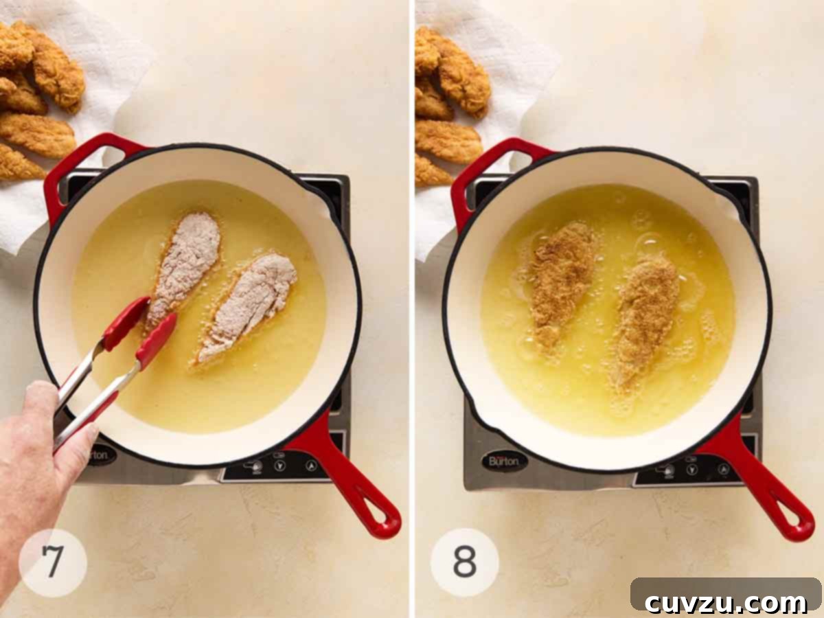 Golden Skillet Chicken Bites 8 A person frying chicken tenders in a skillet; the chicken tenders turned over to cook the other side.