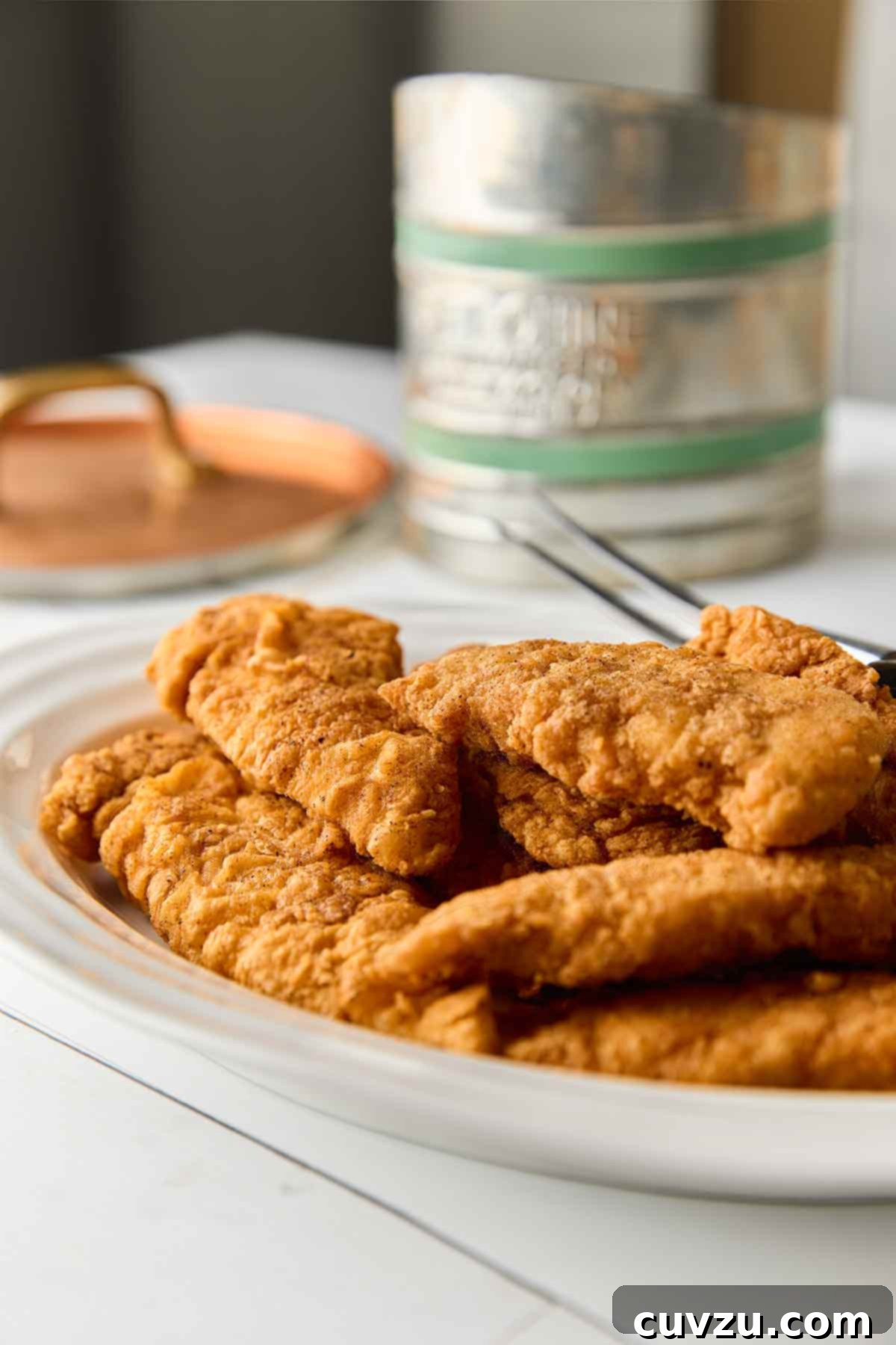 Golden Skillet Chicken Bites 10 A white oval platter of pan-fried chicken tenders.
