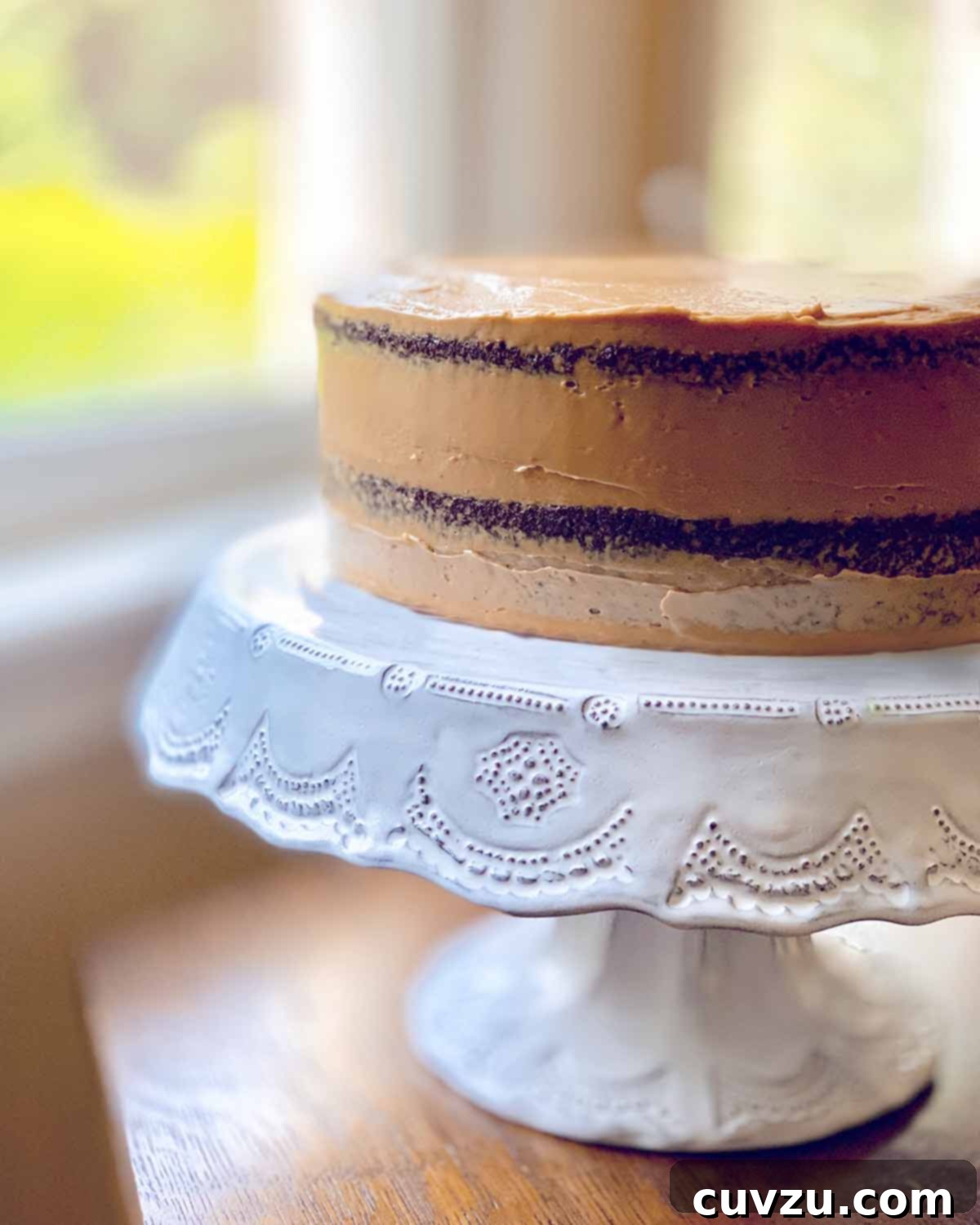Velvet Mocha Delight 4 A complete sour cream mocha cake, expertly frosted with espresso cream, presented on a pristine white cake stand.