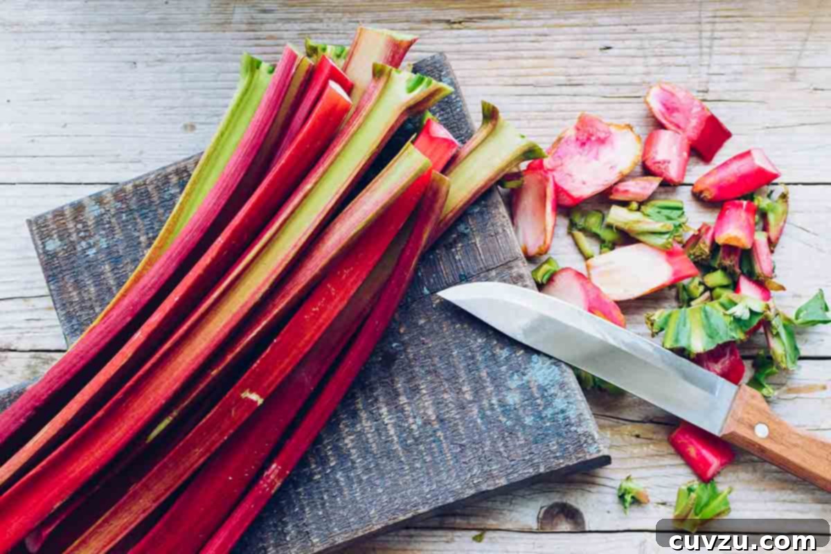 Rhubarb Savvy: Pick It, Keep It, Freeze It 5 Stalks of rhubarb on a cutting board with ends trimmed and a knife beside them, illustrating preparation.