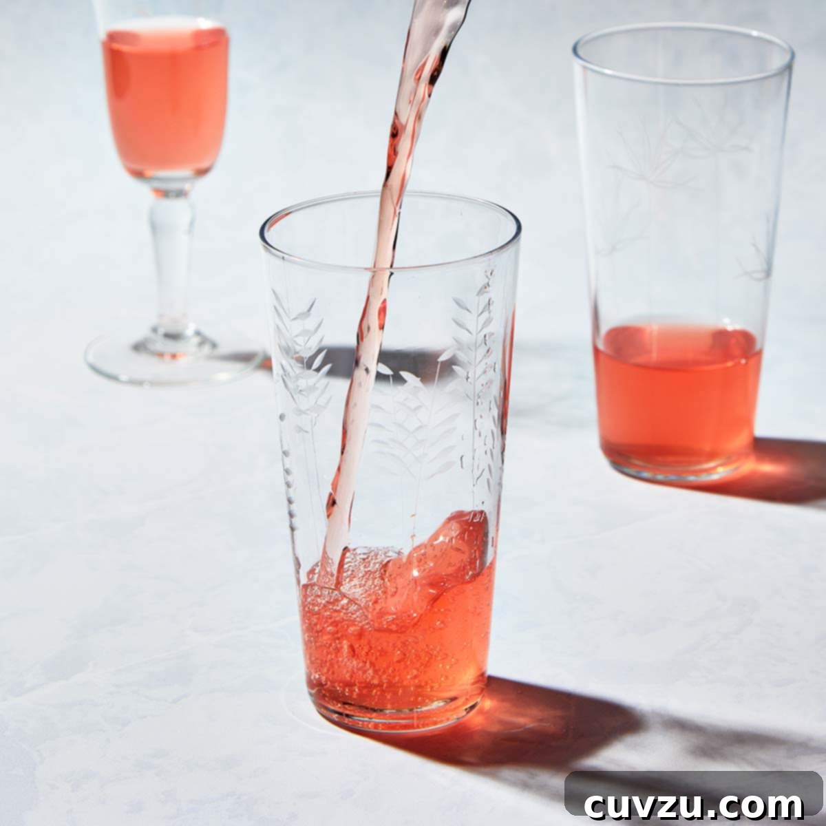 Rhubarb Savvy: Pick It, Keep It, Freeze It 9 Pink rhubarb-infused vodka streaming from a pitcher into an etched glass filled with ice, looking refreshing.