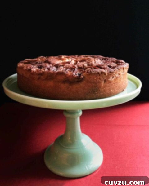 Super moist apple cake presented on a elegant jadeite cake stand, ready to be served.