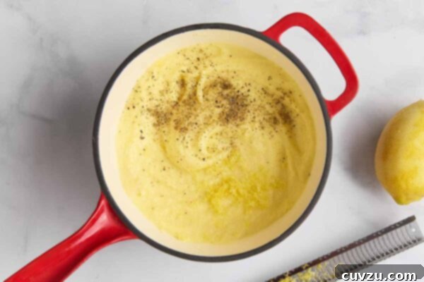 A pot of mashed potatoes topped with lemon zest and black pepper.