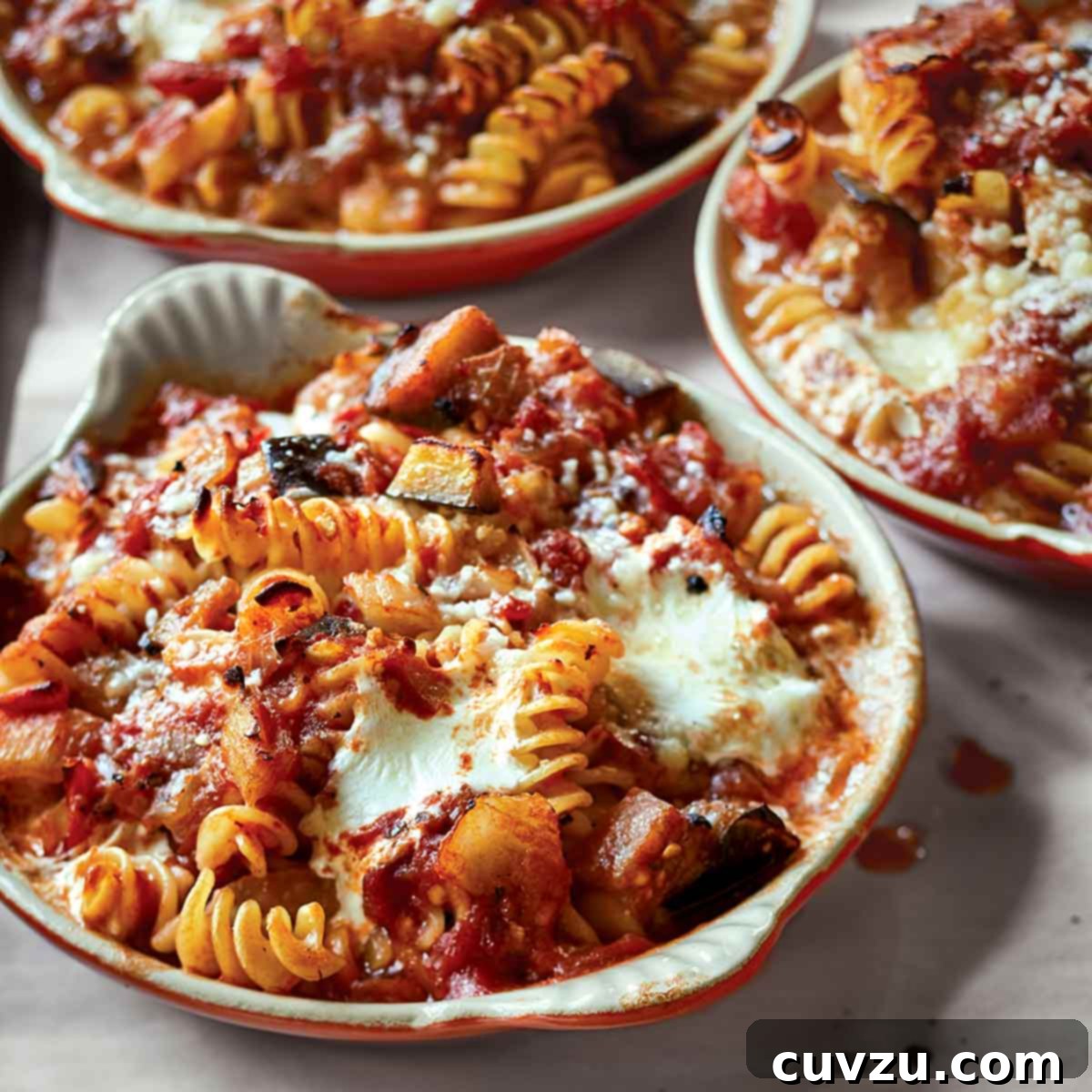 Three round casserole dishes filled with baked pasta with tomatoes and eggplant, a comforting Barefoot Contessa meal.