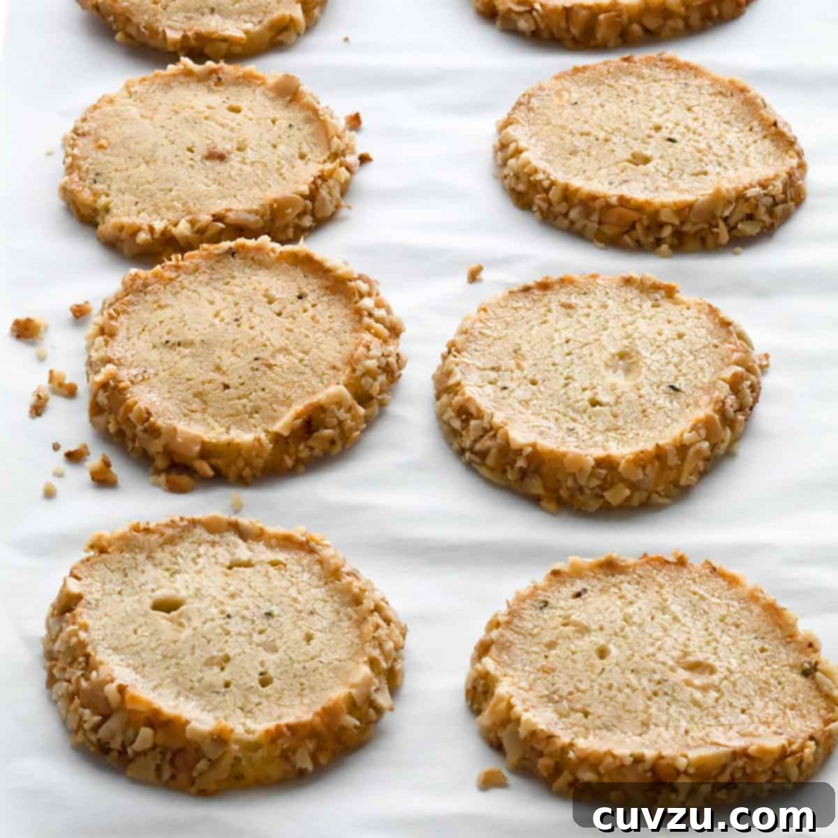 Ten Stilton and walnut crackers arranged in rows on a sheet of parchment, a perfect Barefoot Contessa appetizer.