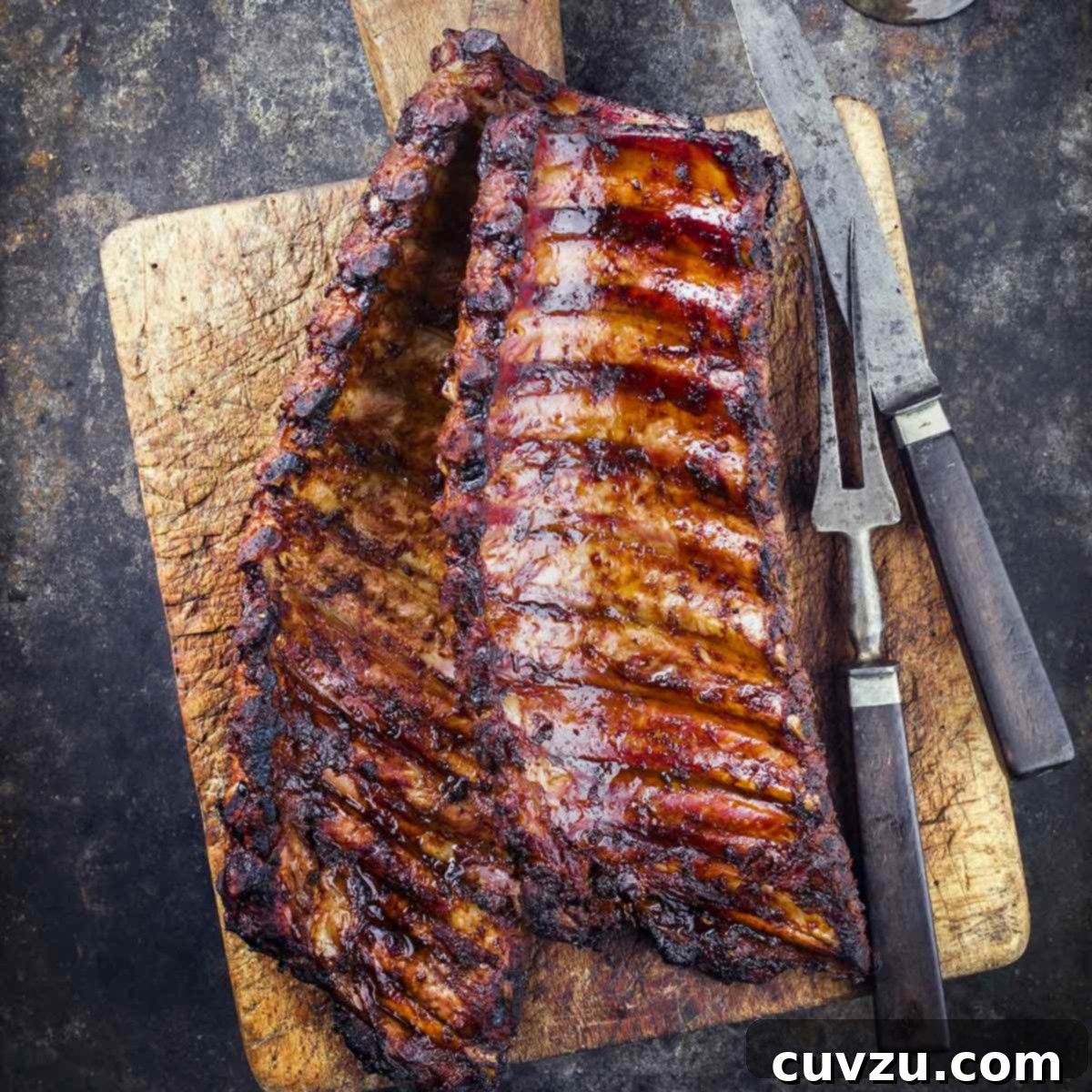 Elevate Your BBQ: 14 Must-Try Smoker Recipes 3 A wooden cutting board topped with two rack of smoked pork ribs.