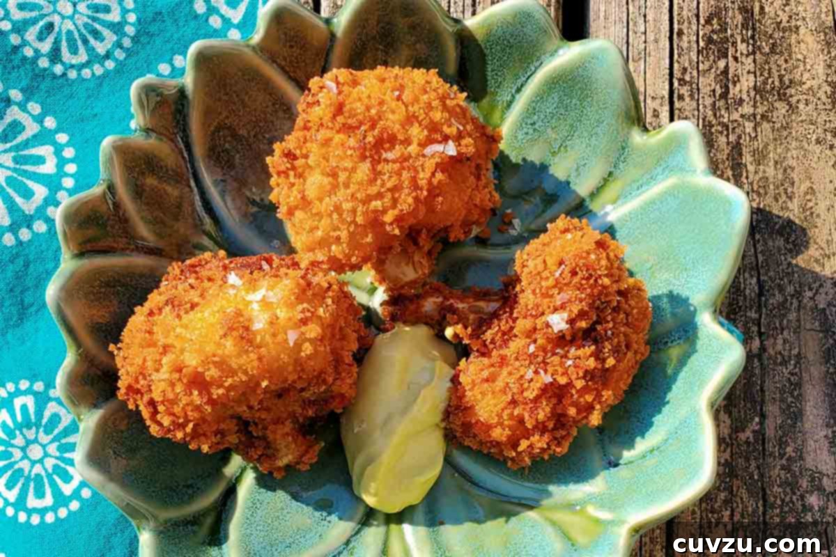 Crispy Cauliflower Poppers 6 A small lotus shaped plate with 3 deep-fried, breaded cauliflower bites and a dollop of mayo dip, all sprinkled with sea salt.