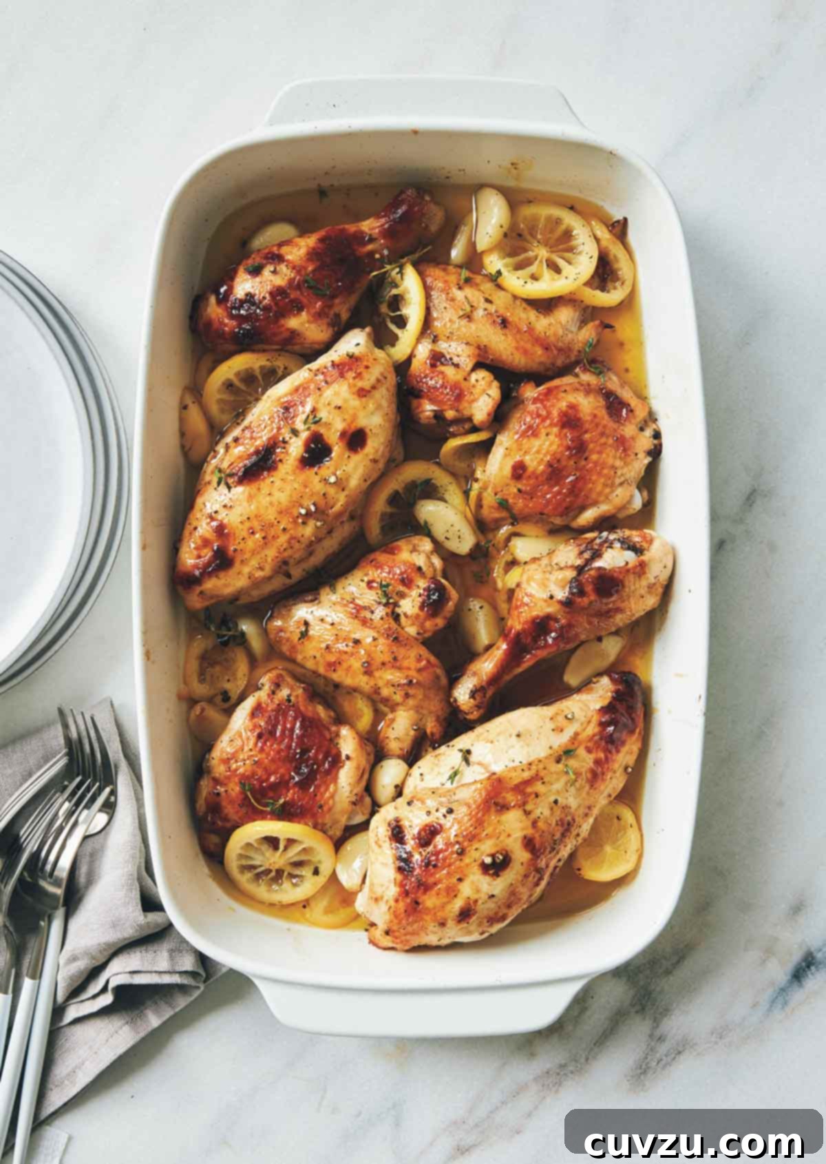 Rosh Hashanah Feasts: 11 Must-Try Recipes 2 A rectangular baking dish filled with roast chicken, lemon slices, and garlic cloves.