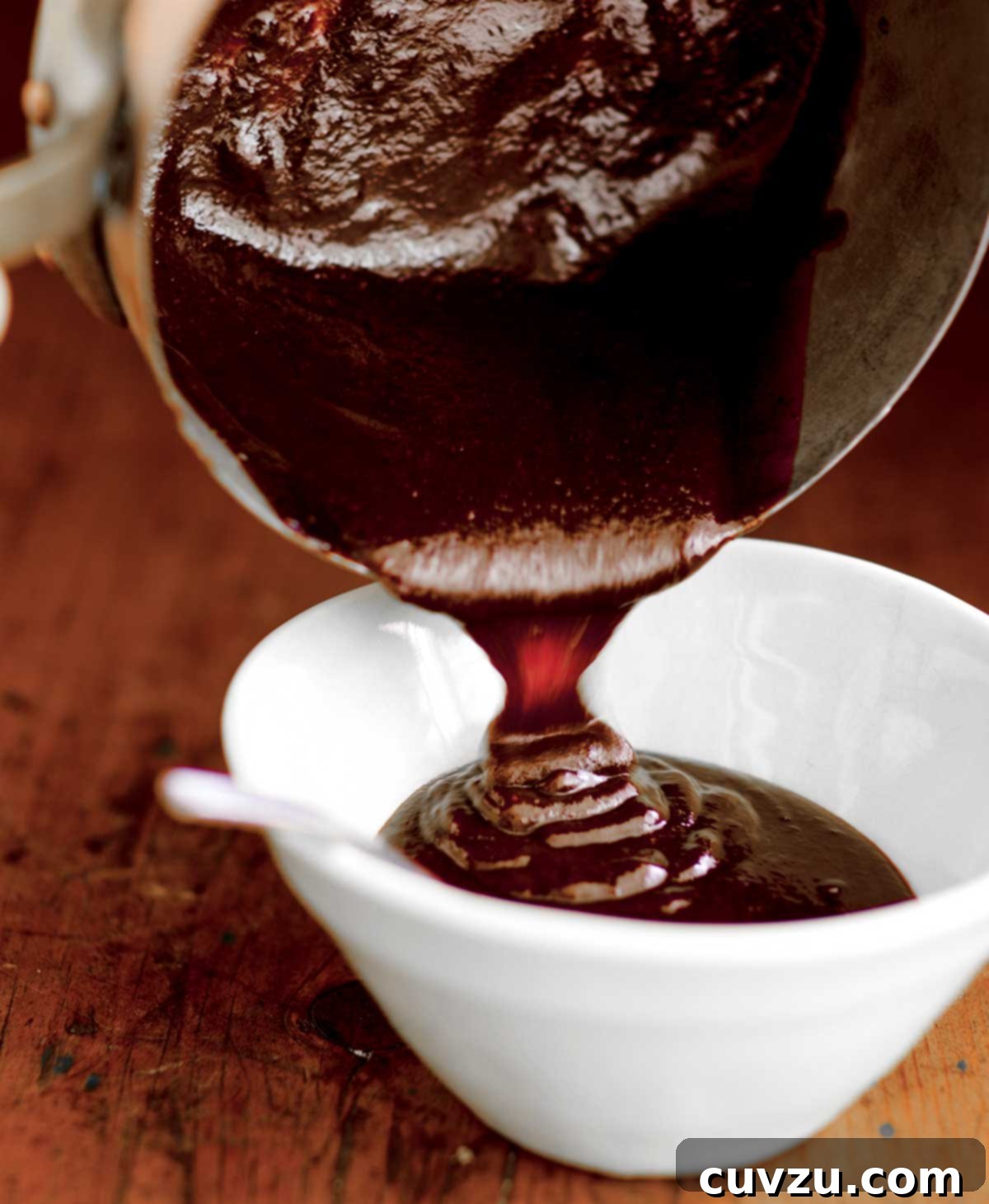 Rich, dark, and glossy homemade barbecue sauce in a small ceramic bowl, ready for slathering or dipping.