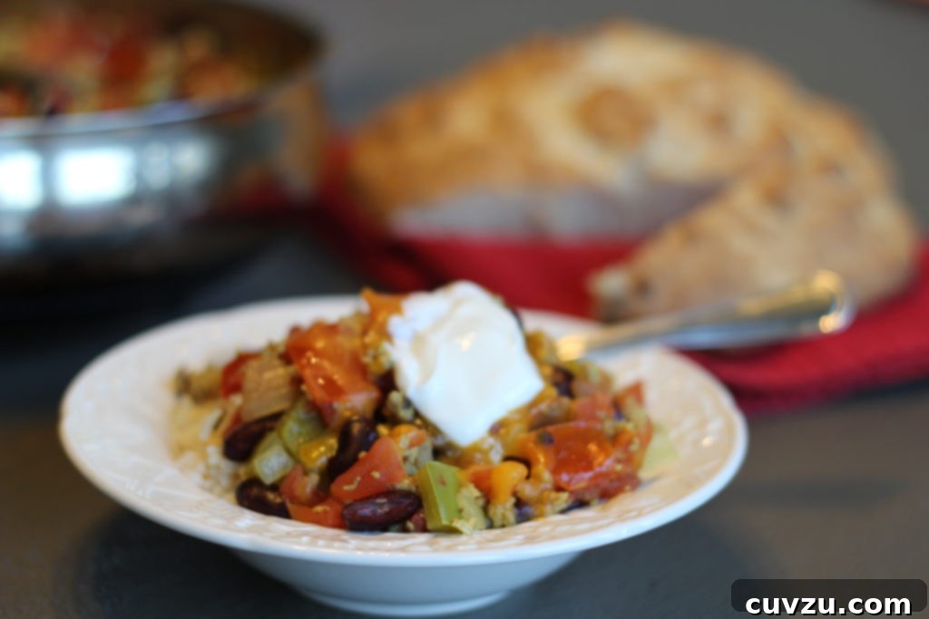 A rustic bowl of President Obama’s famous Chicago chili, rich and hearty, garnished with toppings, with a spoon ready for tasting.