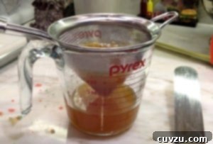 Straining the apricot glaze for the Rainbow Cookies.
