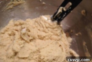 Close up shot of rainbow cookie batter with spatula in it.