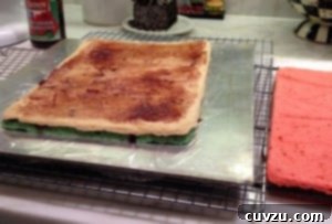 White rainbow cookie cake on silver tray after it is baked.