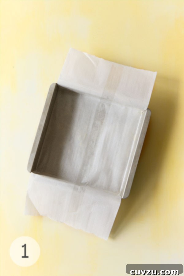 Zesty Lemon Loaf 7 Square metal cake pan lined with parchment paper ready for lemon drizzle cake batter.