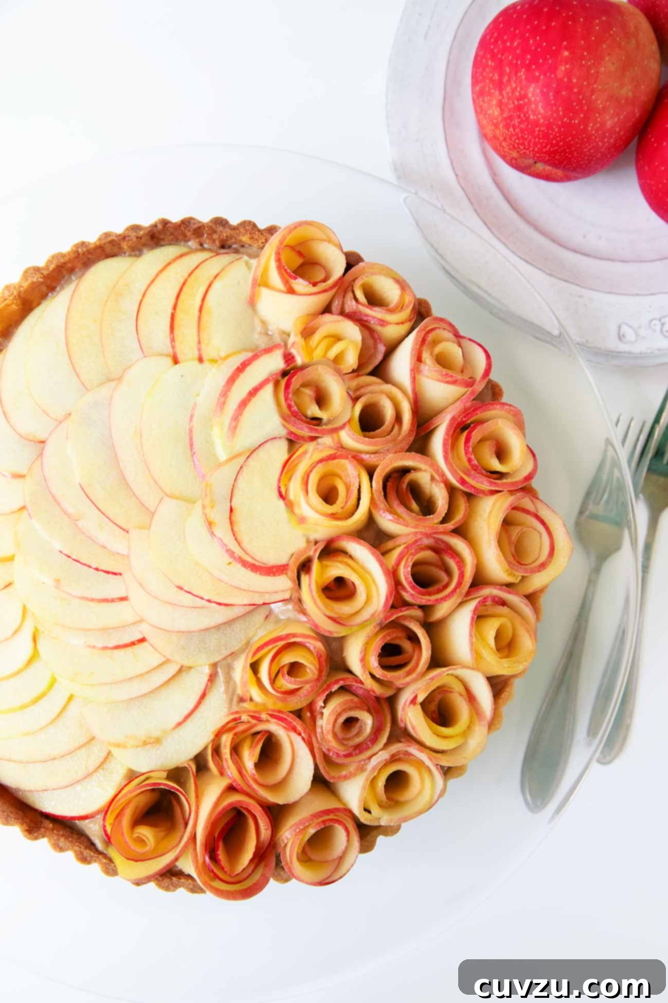 Apple Blossom Tart 5 An exquisitely decorated apple rose tart on a glass cake stand, ready to be served.