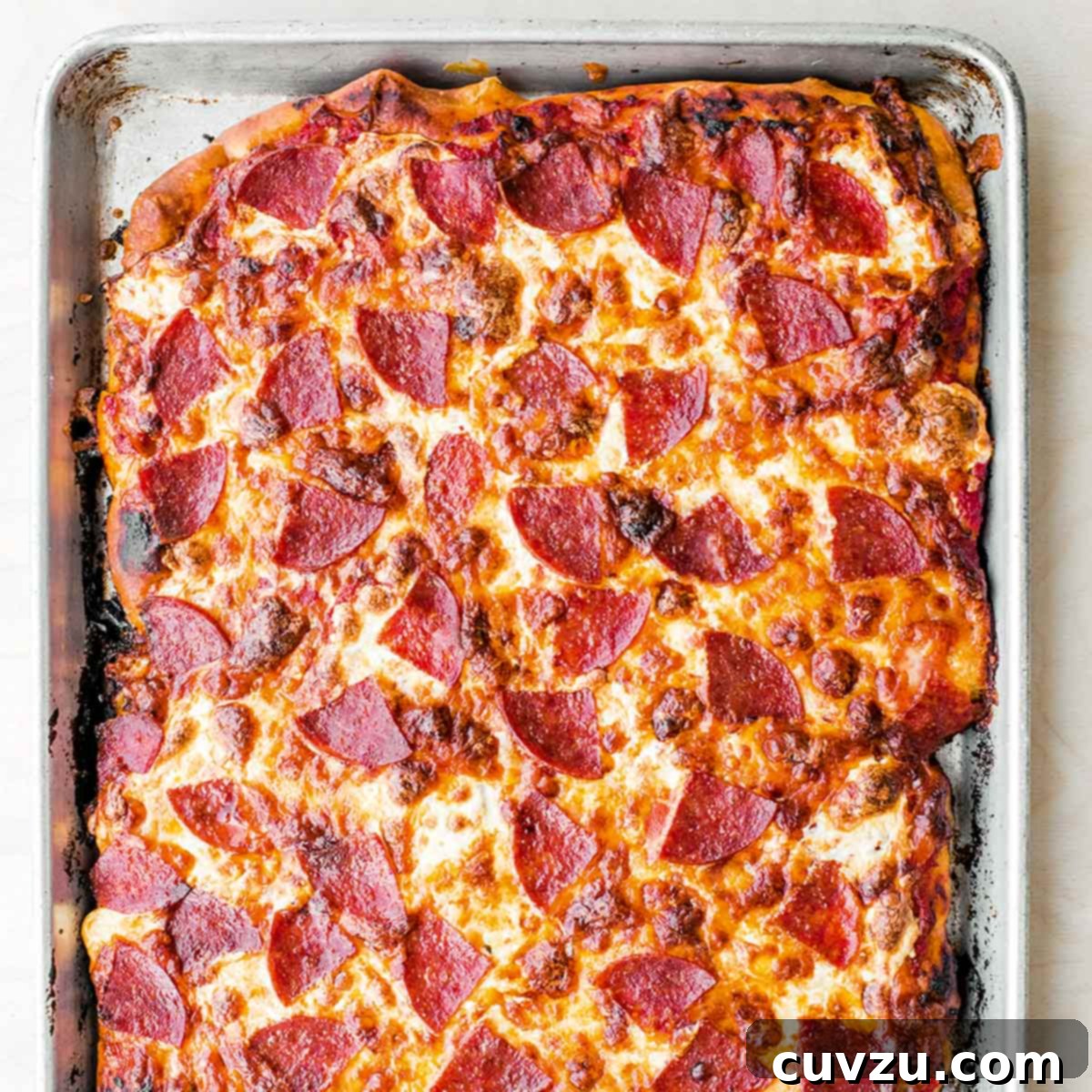 Streamline Your Kitchen: 7 Effortless Sheet Pan Dinners 9 A rectangular pepperoni pan pizza on a rimmed baking sheet.