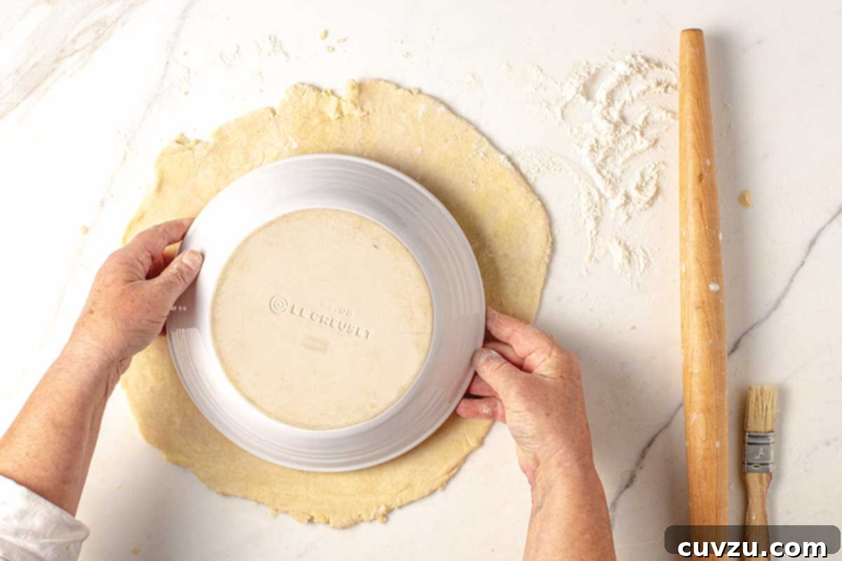 Roll Out a Flawless Pie Crust Every Time 5 A pie plate being placed over a rolled out pie crust to check for adequate size, a critical step for perfect crimping.