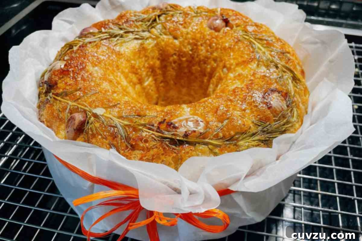 Artisan Rosemary Garlic Sourdough Loaf 8 A rosemary-garlic sourdough bread, beautifully wrapped in paper and tied with an orange ribbon, showcasing its gift-ready appeal.