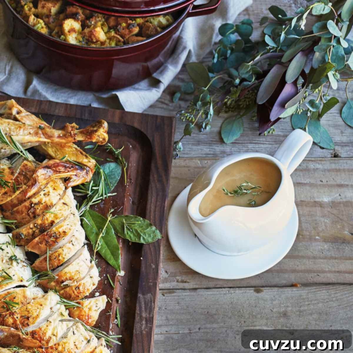 Porcelain Gravy Boat with Saucer on wood table next to sliced turkey.