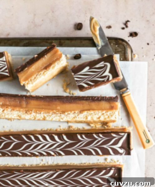 Espresso millionaire shortbread bars cut into long strips on a sheet of parchment paper on a cookies rack with a knife.