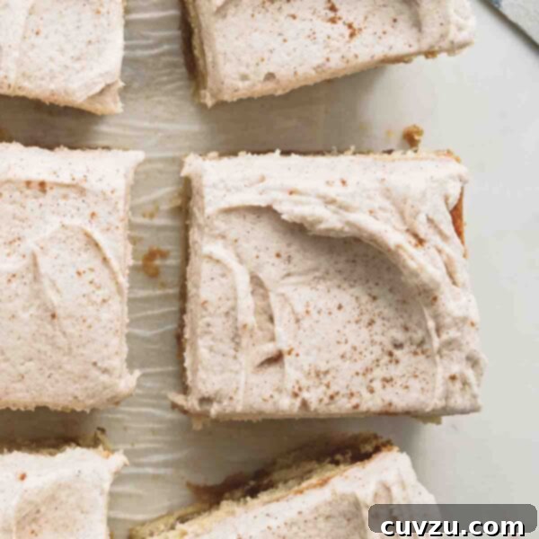 Brown butter snickerdoodle cake cut into six pieces on a piece of parchment paper, with a serving knife nearby.