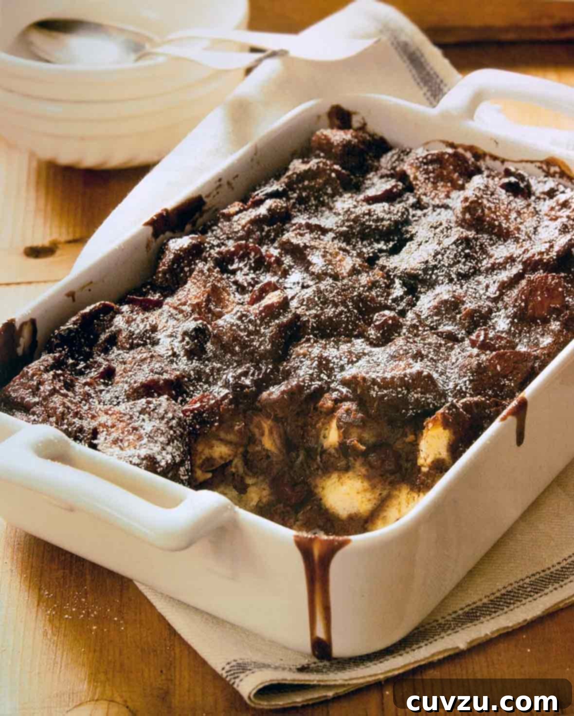A generous portion of Dorie Greenspan's rich Chocolate Bread Pudding, presented in a rustic yet elegant style, highlighting its indulgent texture and comforting appeal.
