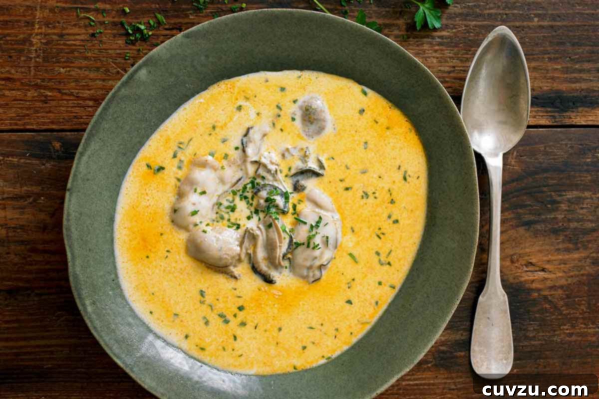 8 Epic Christmas Centerpieces for Your Feast 2 A ceramic bowl filled with oyster stew with several oysters in the center and a spoon resting beside the bowl.
