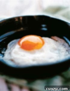 A perfect fried egg in a small black skillet.