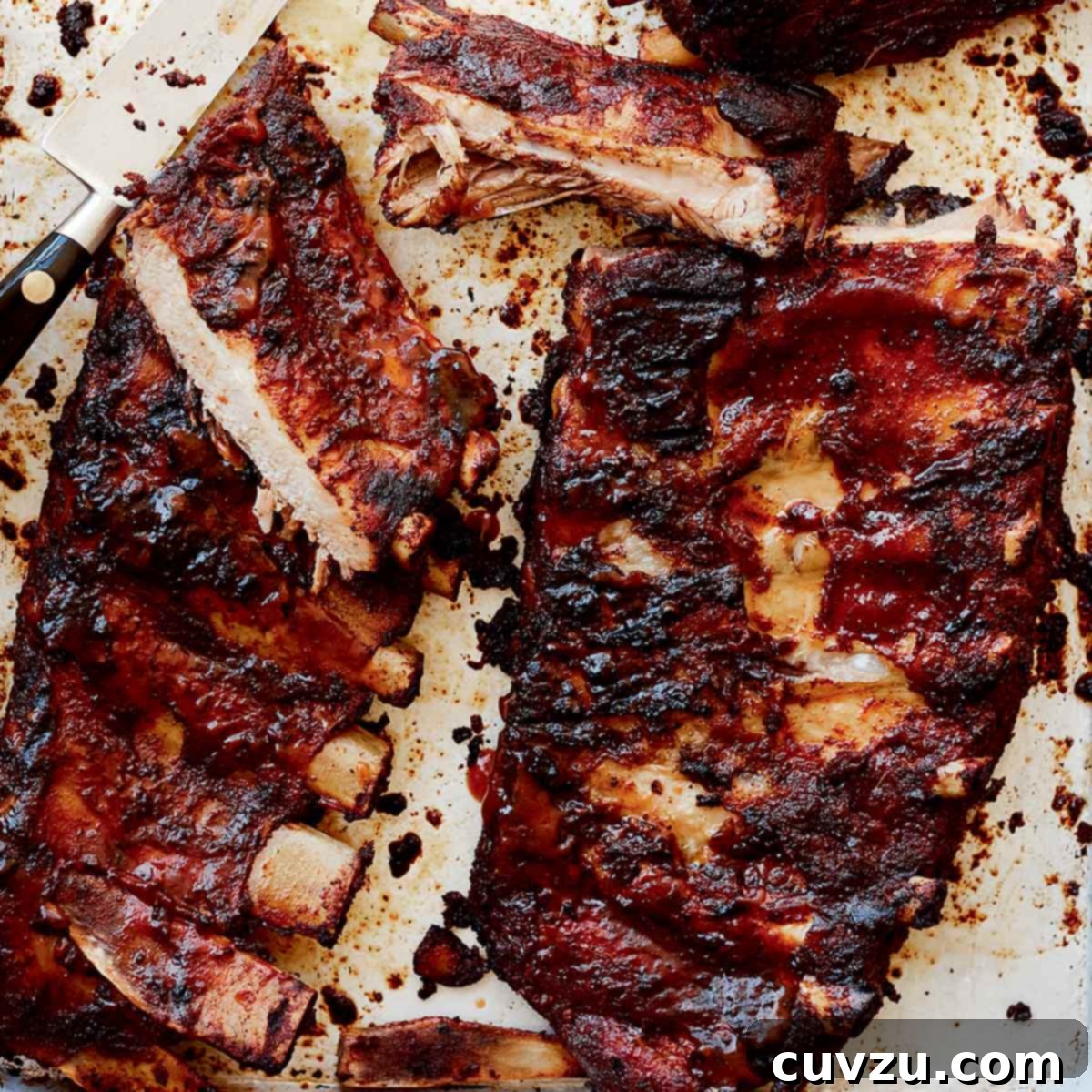 Two slabs of St. Louis style ribs from Alex Guarnaschelli with some cut into individual ribs and a knife lying in the middle.