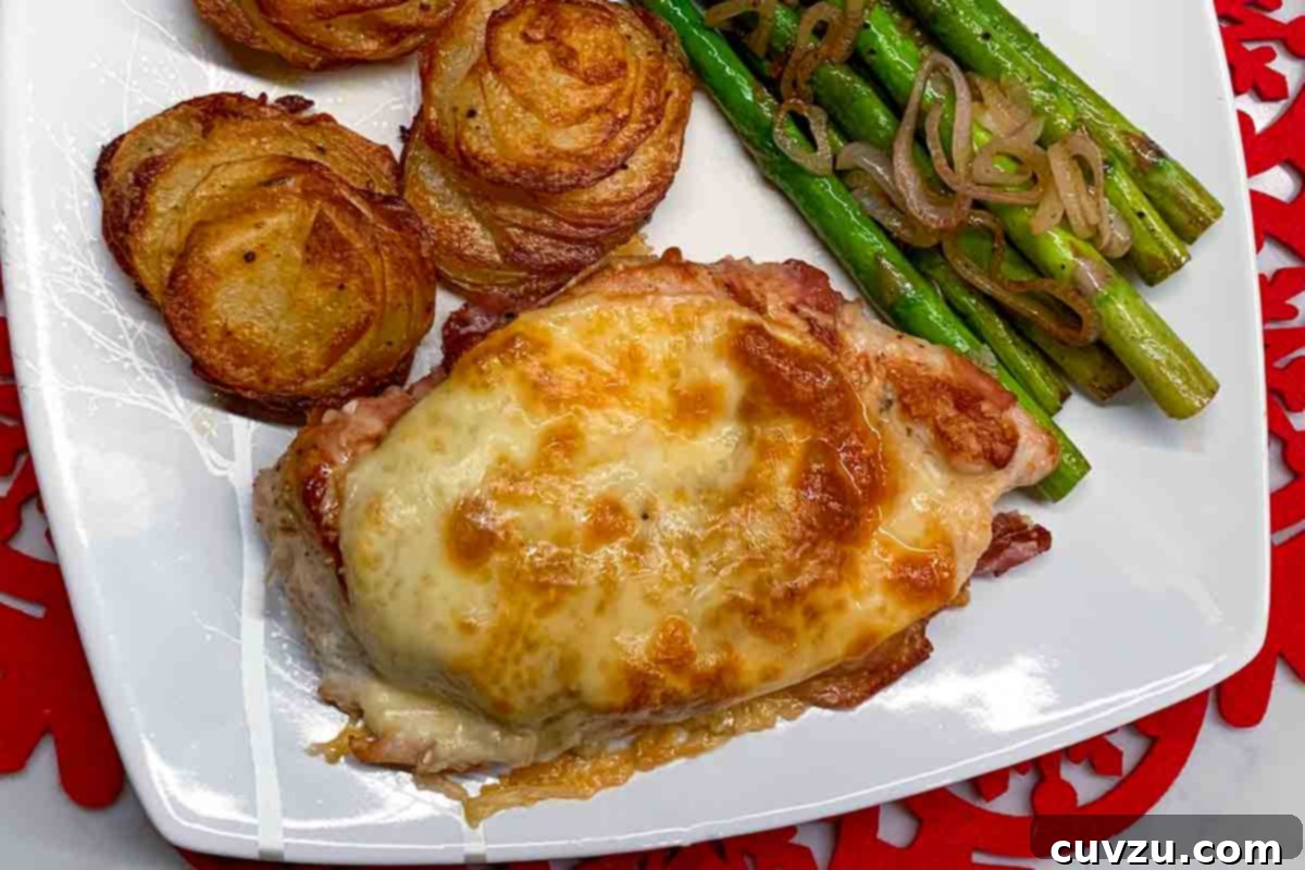Crisp Prosciutto-Wrapped Chicken with Tender Asparagus 5 A white plate with prosciutto-wrapped chicken with asparagus on the side